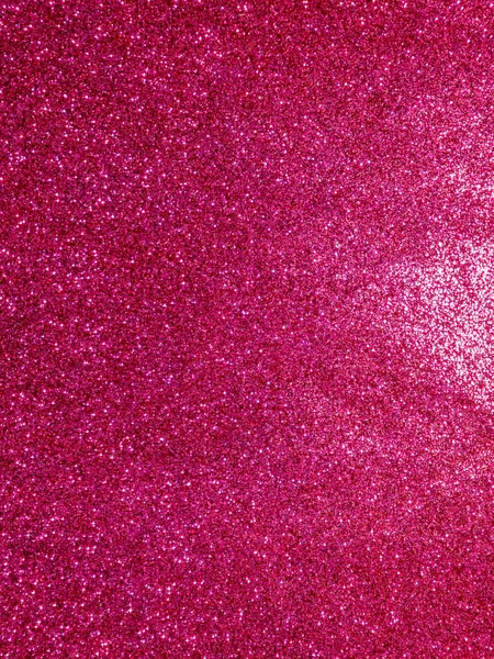 Canlı pembe bir parıltı yüzeyinin makro görüntüsü. Parlak dokusu, bayram tasarımları, parti davetiyeleri, duvar kağıtları ve soyut kavramlar için mükemmel bir şenlik ve büyüleyici bir zemin oluşturuyor..