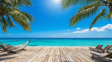 Sun loungers on a wooden pier overlooking a calm turquoise sea under a bright sunny sky. Palm leaves frame the perfect summer vacation or travel background.