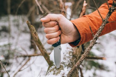 sharp pocketknife in a snowy woods  clipart