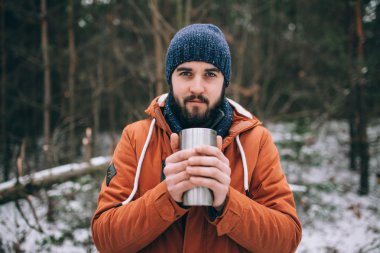 sakallı adam termos bardak sıcak içecekle 