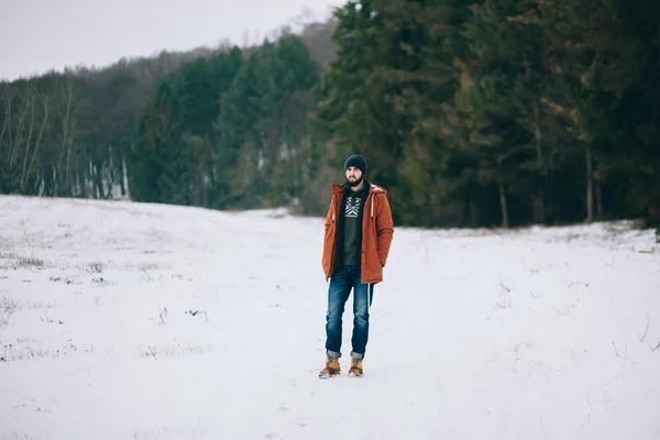 Бородатый человек идет по дороге зимой — стоковое фото