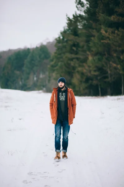 Bebaarde man lopen op de weg in de winter — Stockfoto
