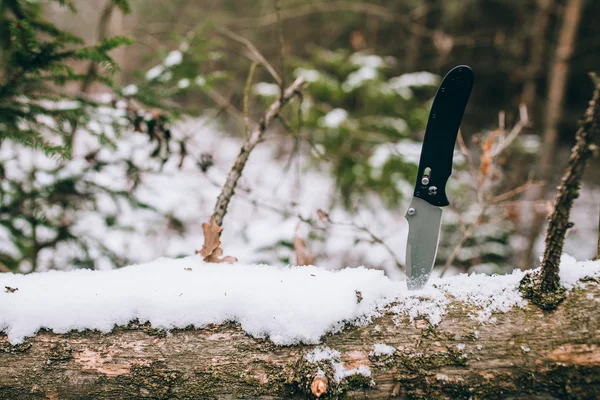 Coltello da tasca affilato in un bosco innevato — Foto Stock