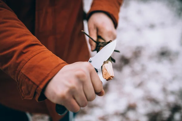 A man uses a knife to whittle a stick — Stock Photo, Image