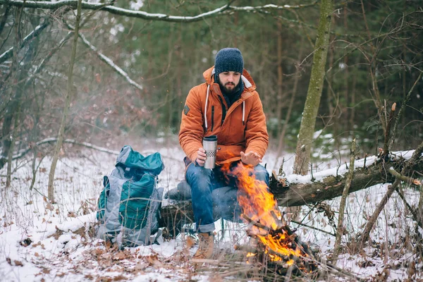 Voyageurs réchauffés par le feu dans la forêt d'hiver — Photo