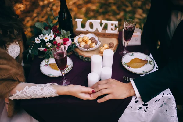 Recién casados celebrando en la mesa al aire libre —  Fotos de Stock