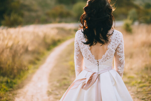 Beautiful stylish bride walking in fields