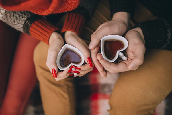 Heart shaped cups in hands — Stock Photo, Image