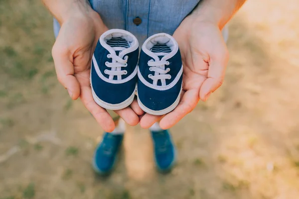 Mãos segurando sapatos de bebê — Fotografia de Stock