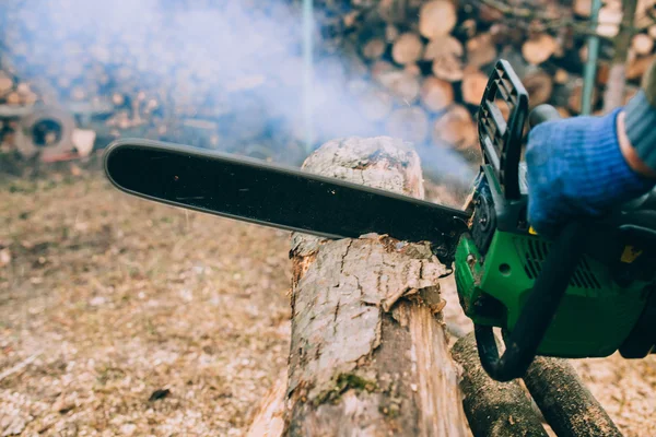 Mains masculines tronc de coupe avec tronçonneuse — Photo