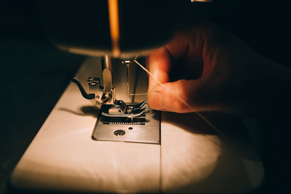 Женщина работает на швейной машине
