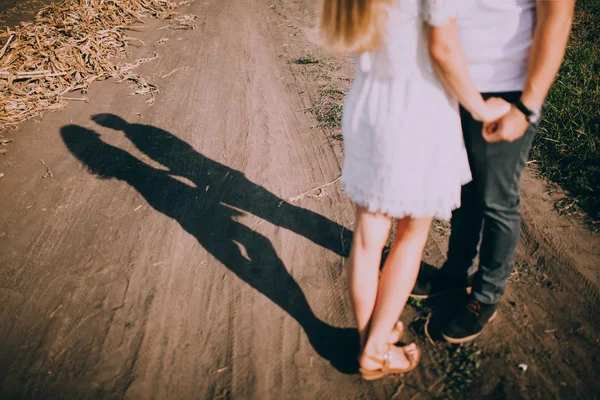 Pareja cogida de la mano en camino — Foto de Stock