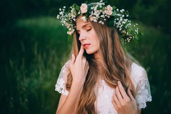Kvinna med krans av vilda blommor — Stockfoto