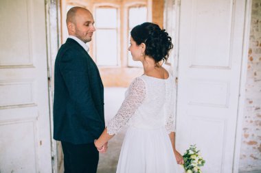 Gelin ve damat el ele tutuşuyorlar.