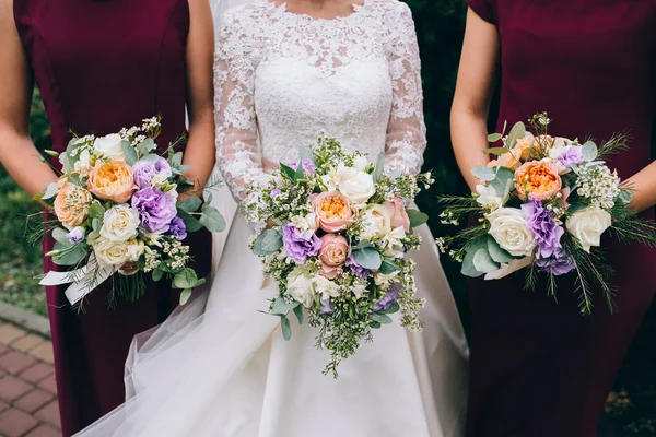 Novia y damas de honor sosteniendo ramos — Foto de Stock