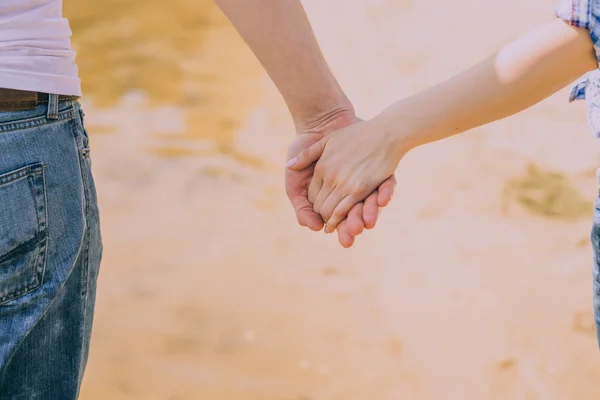 Pareja cogida de la mano en la playa —  Fotos de Stock