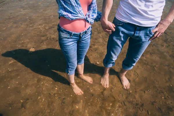Pareja cogida de la mano en la playa — Foto de Stock