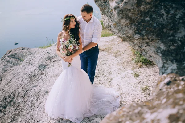 Bruid en bruidegom op een klif — Stockfoto
