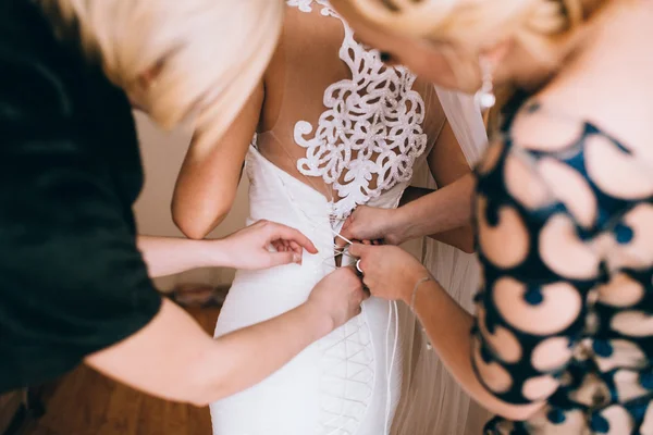 Mani che aiutano con corsetto bianco della sposa — Foto Stock