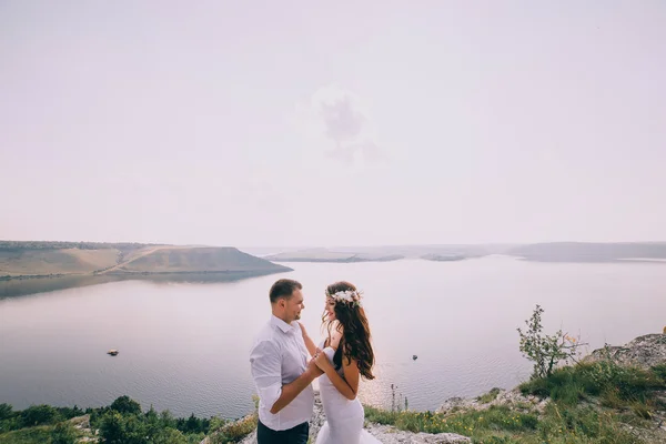 Sposa e sposo su una scogliera — Foto Stock