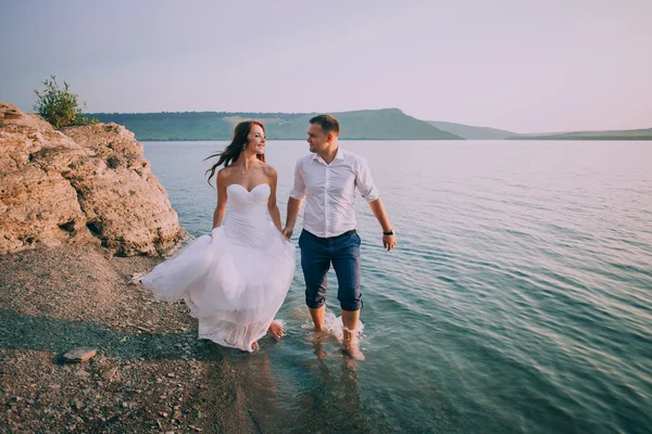 Casal romântico correndo na praia — Fotografia de Stock