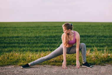 Blond woman stretches the body
