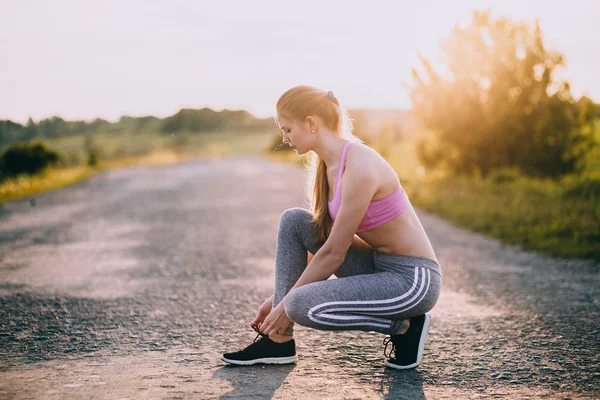 Frau schnürt Laufschuhe — Stockfoto