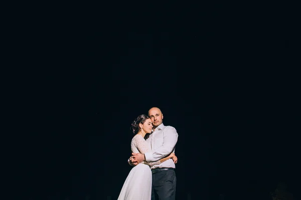 Os recém-casados abraçam-se em um contexto do céu noturno — Fotografia de Stock