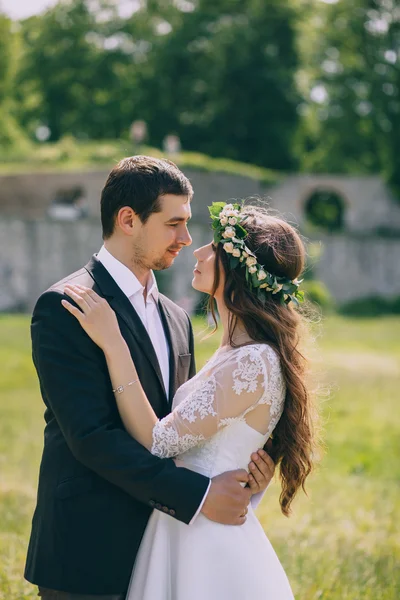 Recém-casados abraçar pelo velho castelo — Fotografia de Stock