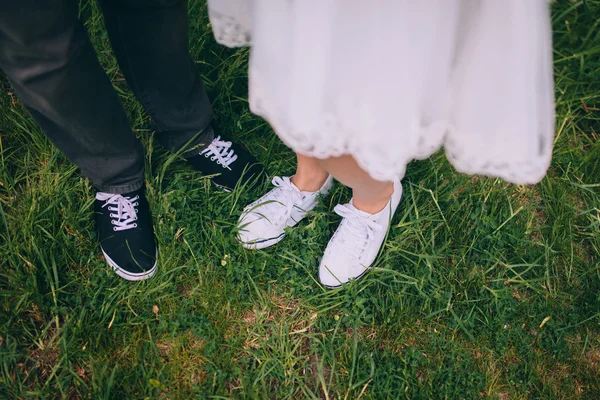 Recém-casados em pé na grama — Fotografia de Stock