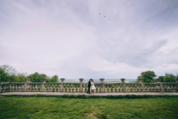 Recién casados caminando por las escaleras del viejo castillo — Foto de Stock