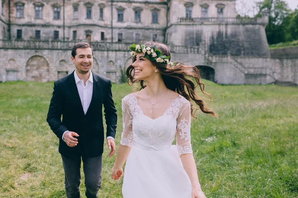 Recién casados corriendo por el viejo castillo — Foto de Stock