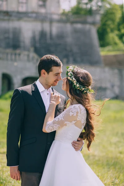 Newlyweds embrace by the old castle — Stock Photo, Image