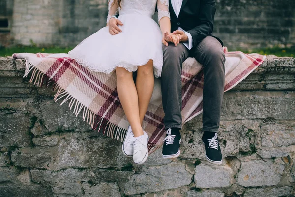 Newlyweds sitting by the stairs of old castle — Stock Photo, Image