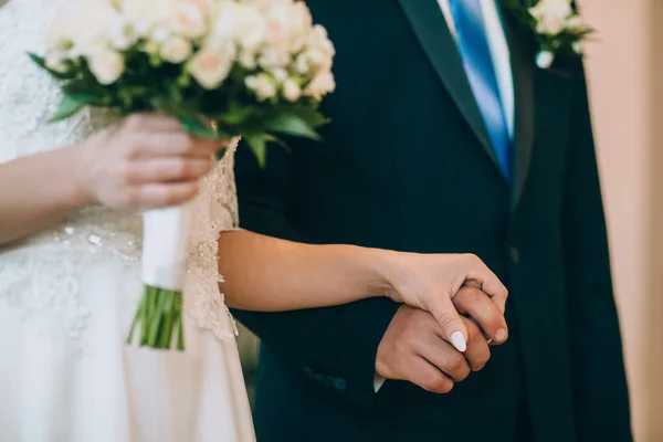 Newlyweds with wild flowers bouquet — Stock Photo, Image