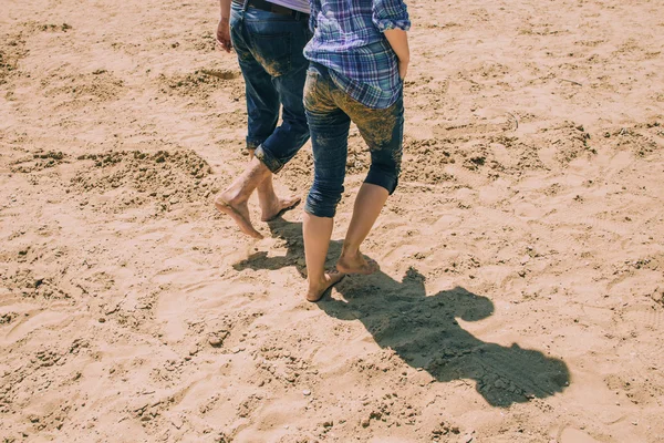 Koppel hand in hand op het strand — Stockfoto