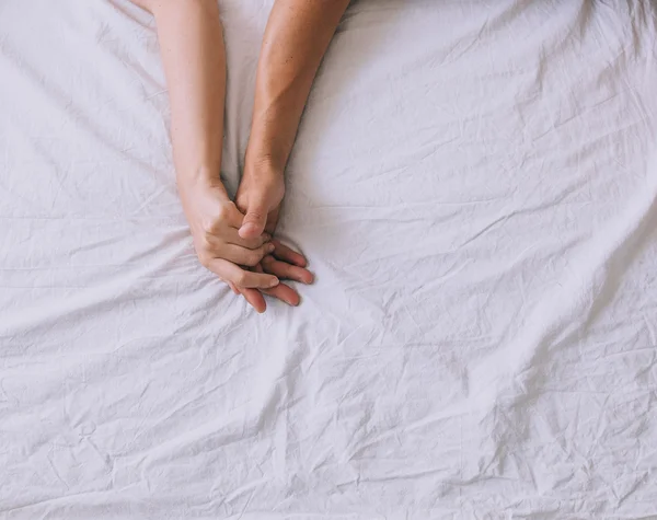 Hands of a couple inn a bed — Stock Photo, Image