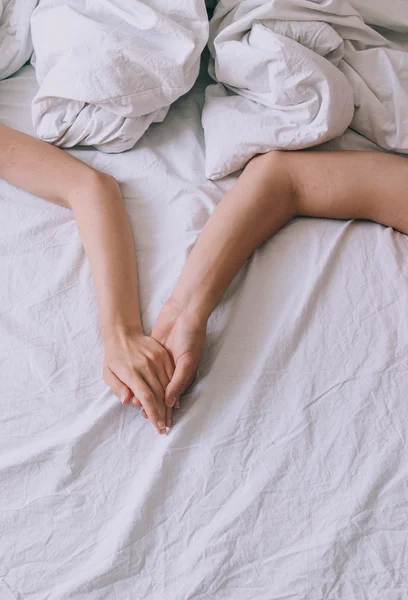Hands of a couple inn a bed — Stock Photo, Image