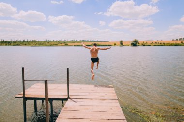 Adam iskeleden suya atlar.