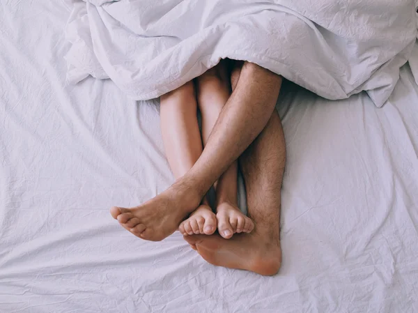 Feet of couple side by side in bed — Stock Photo, Image
