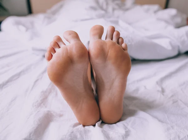 Human feet in bed — Stock Photo, Image