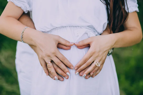 Händer på gravid mage — Stockfoto