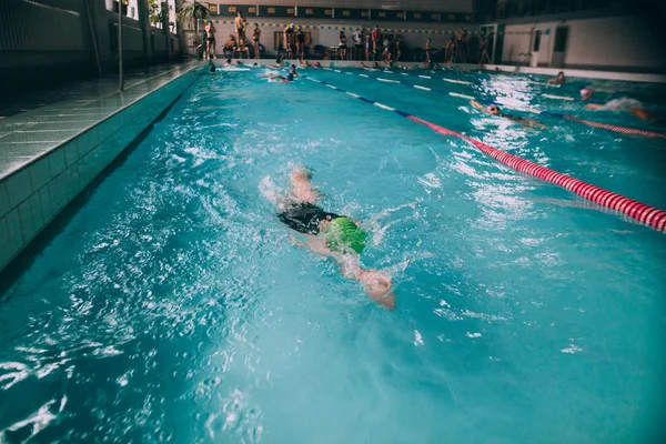 Люди плавают в закрытом бассейне — стоковое фото