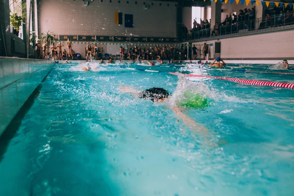 Persone che nuotano in piscina coperta — Foto Stock