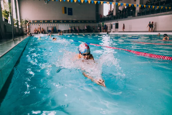 Persone che nuotano in piscina coperta — Foto Stock