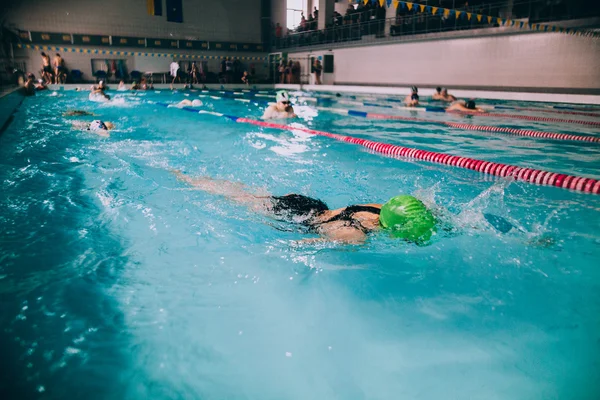 Persone che nuotano in piscina coperta — Foto Stock