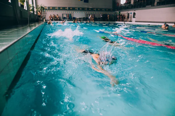 Personas nadando en piscina cubierta — Foto de Stock