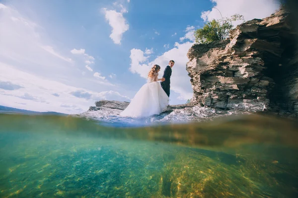 Bride and groom on a cliff — Stock Photo, Image