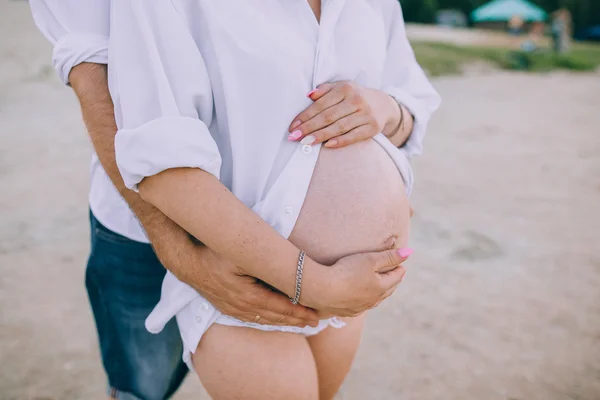 Pregnant couple walking on beach — Stock Photo, Image