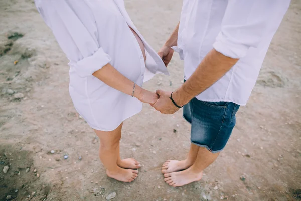 Zwangere paar wandelen op strand — Stockfoto